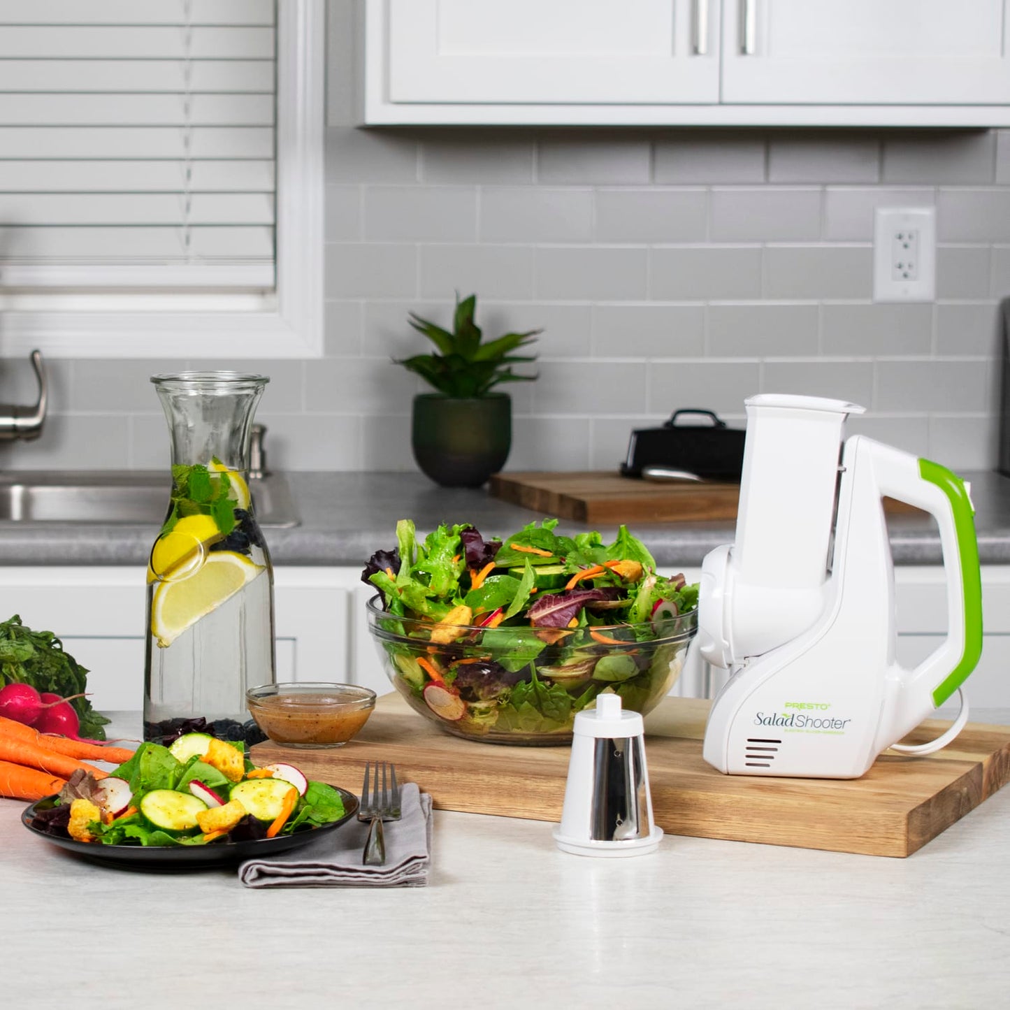 White and green electric vegetable slicer with fresh salad bowls and vinaigrette on kitchen countertop under $100 collections