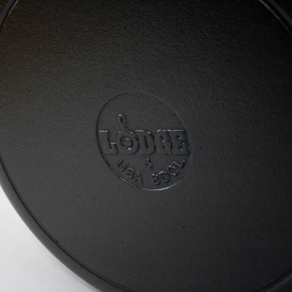 Close-up of black cast iron cookware base with embossed Lodge logo in kitchenware and Lodge cast iron collections under $100