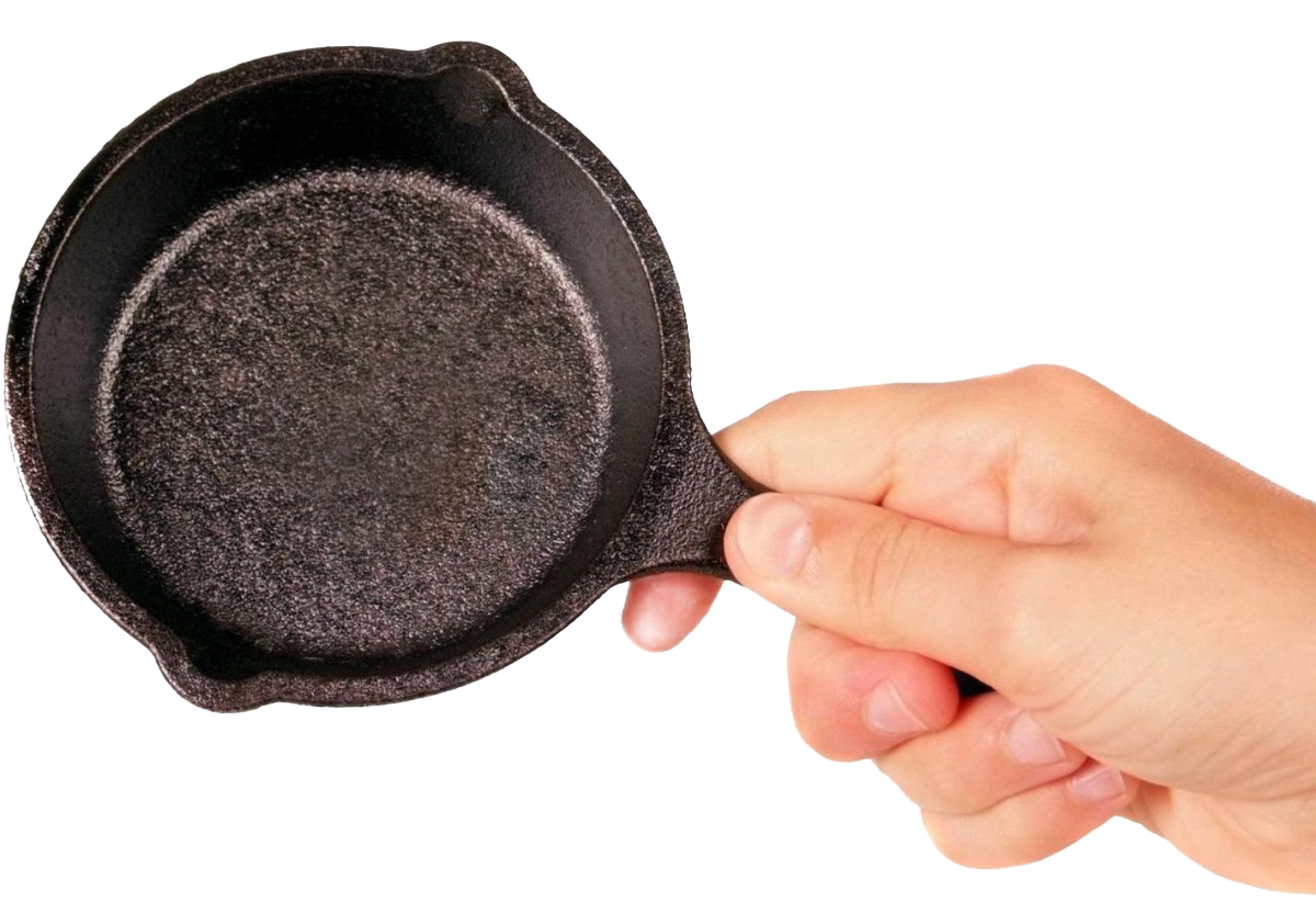 Hand holding a small 3.5-inch black cast iron mini skillet from kitchenware and Lodge Cast Iron collection