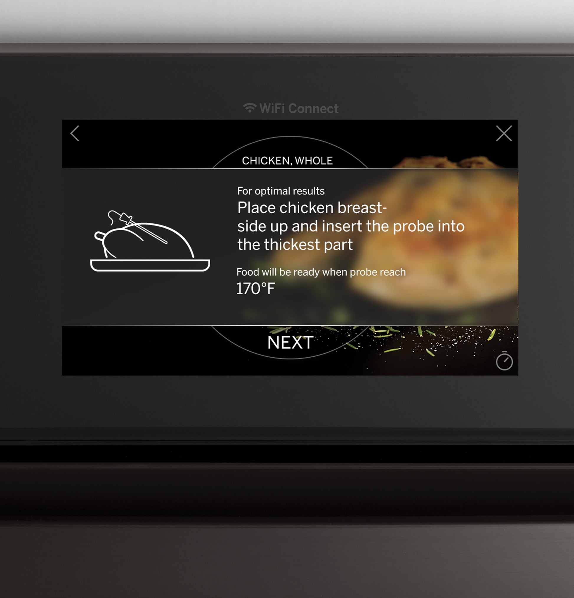 Touchscreen on smart built-in wall oven displaying instructions for cooking whole chicken with temperature probe guidance.