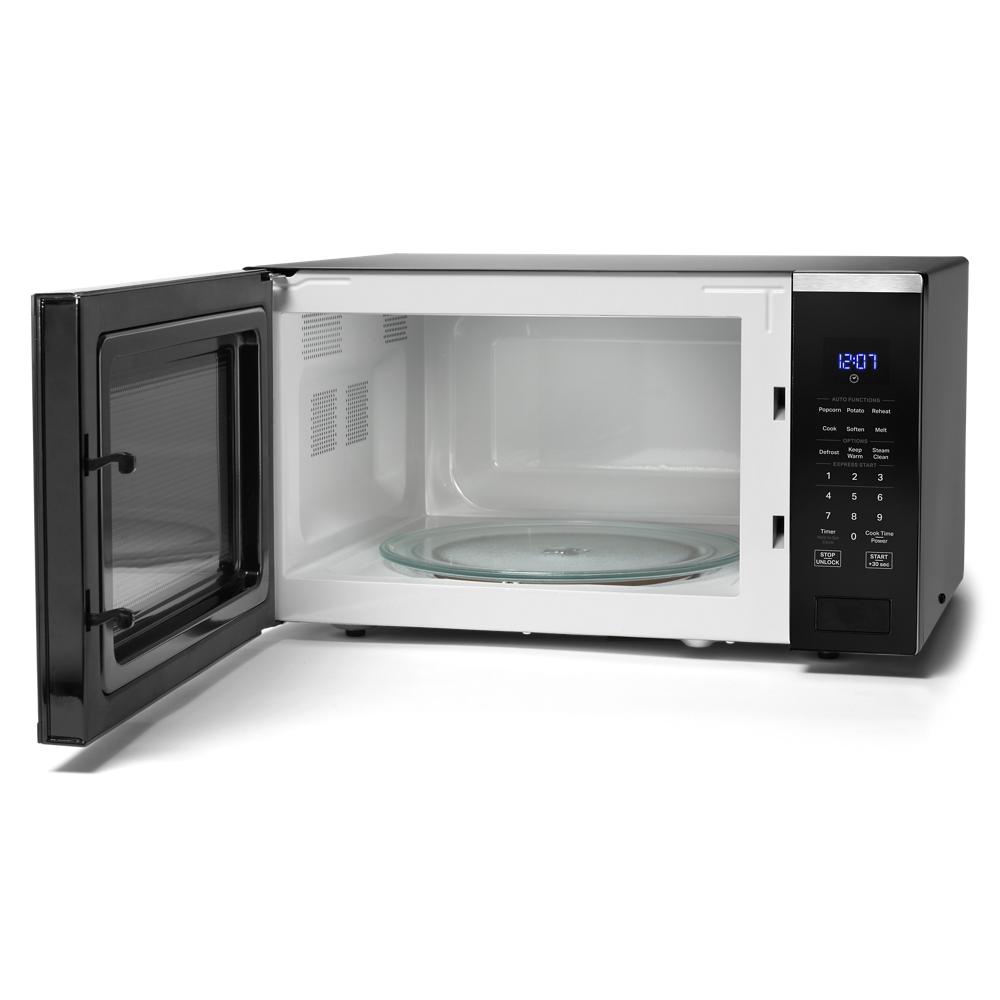 Black Whirlpool sensor microwave with open door showing glass turntable in Microwaves at Hartville Hardware
