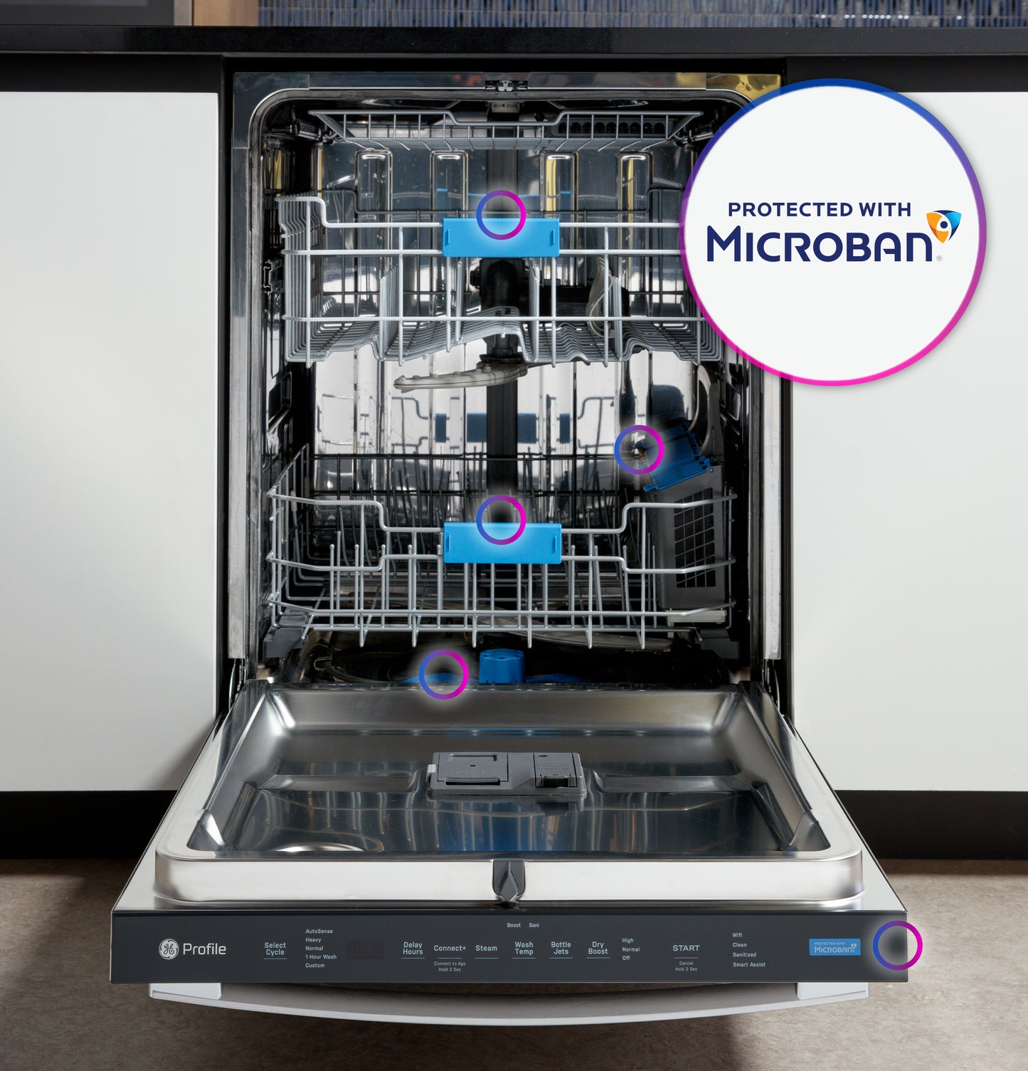 Open stainless interior dishwasher with top control panel and Microban antimicrobial protection badge visible in kitchen setting