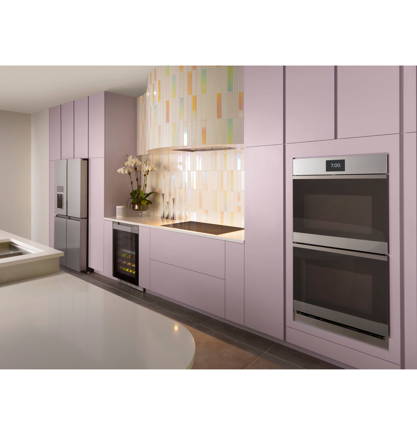 Contemporary kitchen with lavender cabinetry, built-in double ovens, refrigerator, wine cooler, and colorful tiled backsplash