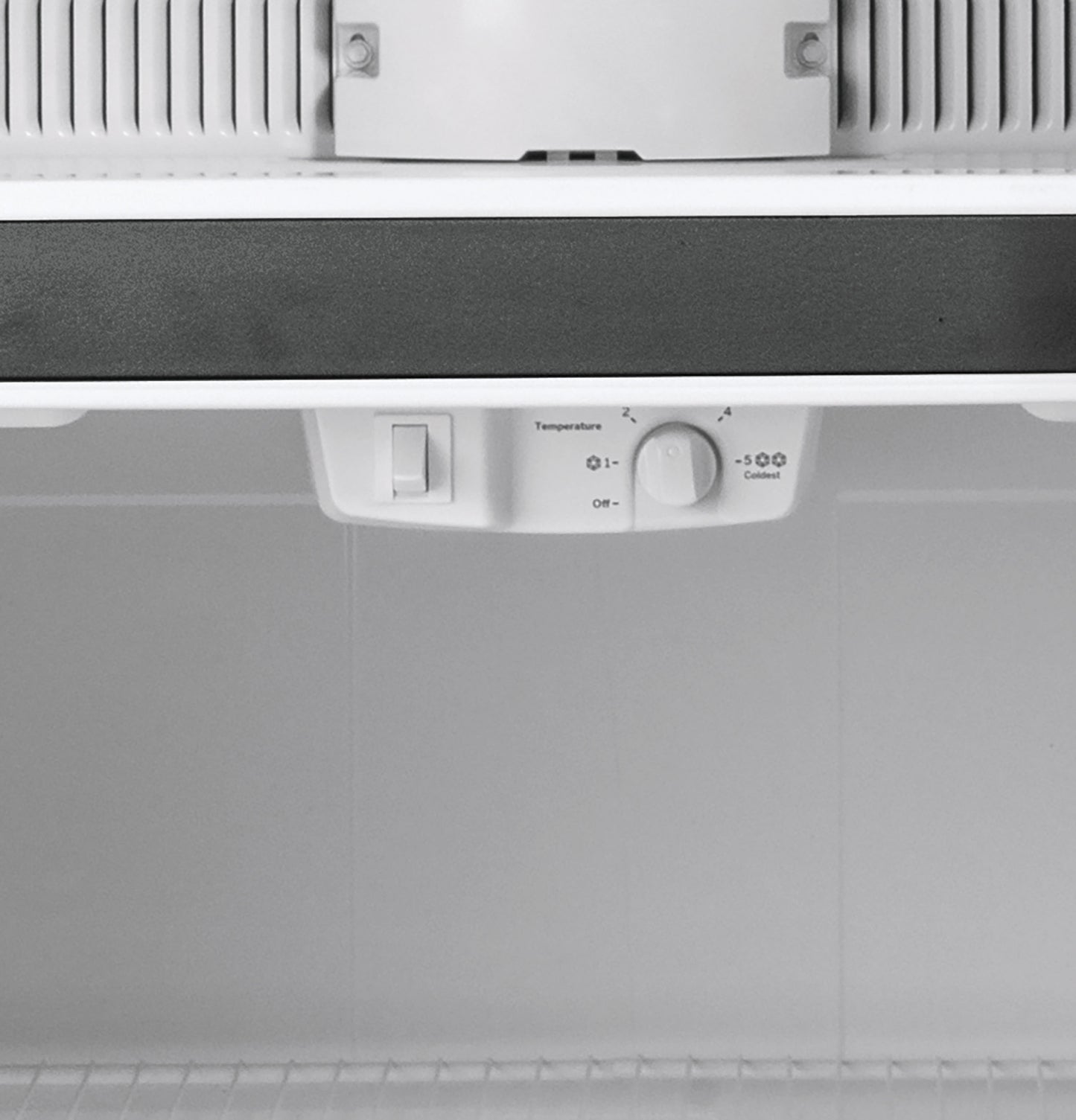 Close-up of temperature control dial inside a white top-freezer refrigerator from kitchen and home improvement appliances collection