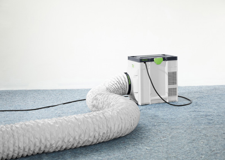 Compact air filtration unit with flexible ducting positioned on carpet for tools and home improvement tasks