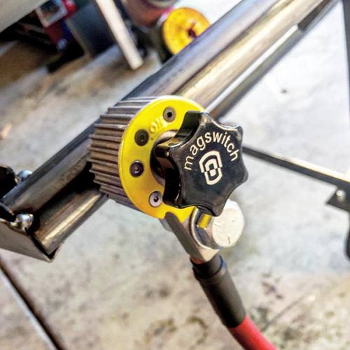 Close-up of a Magswitch magnetic welding ground clamp with cooling fins in a workshop setting under 100 dollars