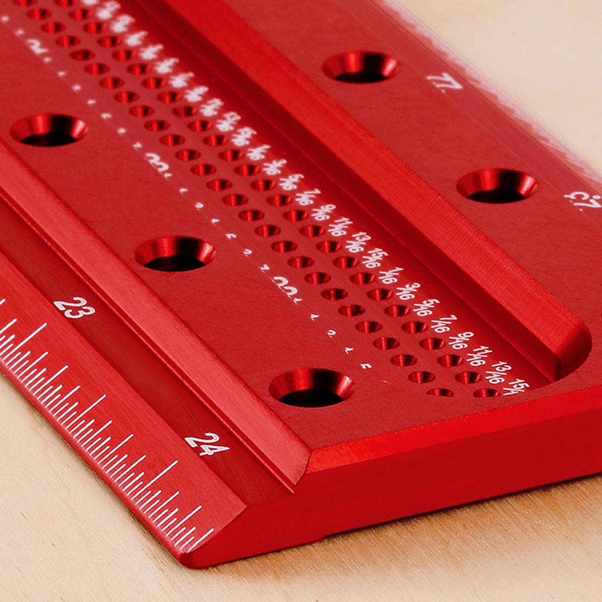 Close-up of red anodized metal T square edge with precise laser-etched measurements for woodworking tools collection