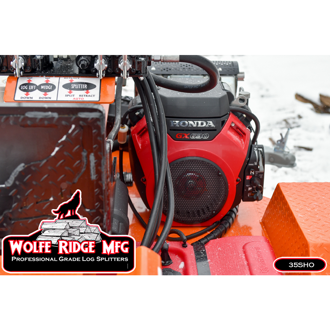 Close-up of red Honda GX630 engine and hydraulic controls on heavy-duty Wolfe Ridge log splitter outdoors in snow