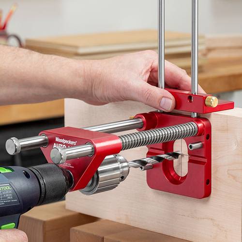 Red metal drill guide attachment with adjustable rods and clamp for precise drilling in power tool accessories collection