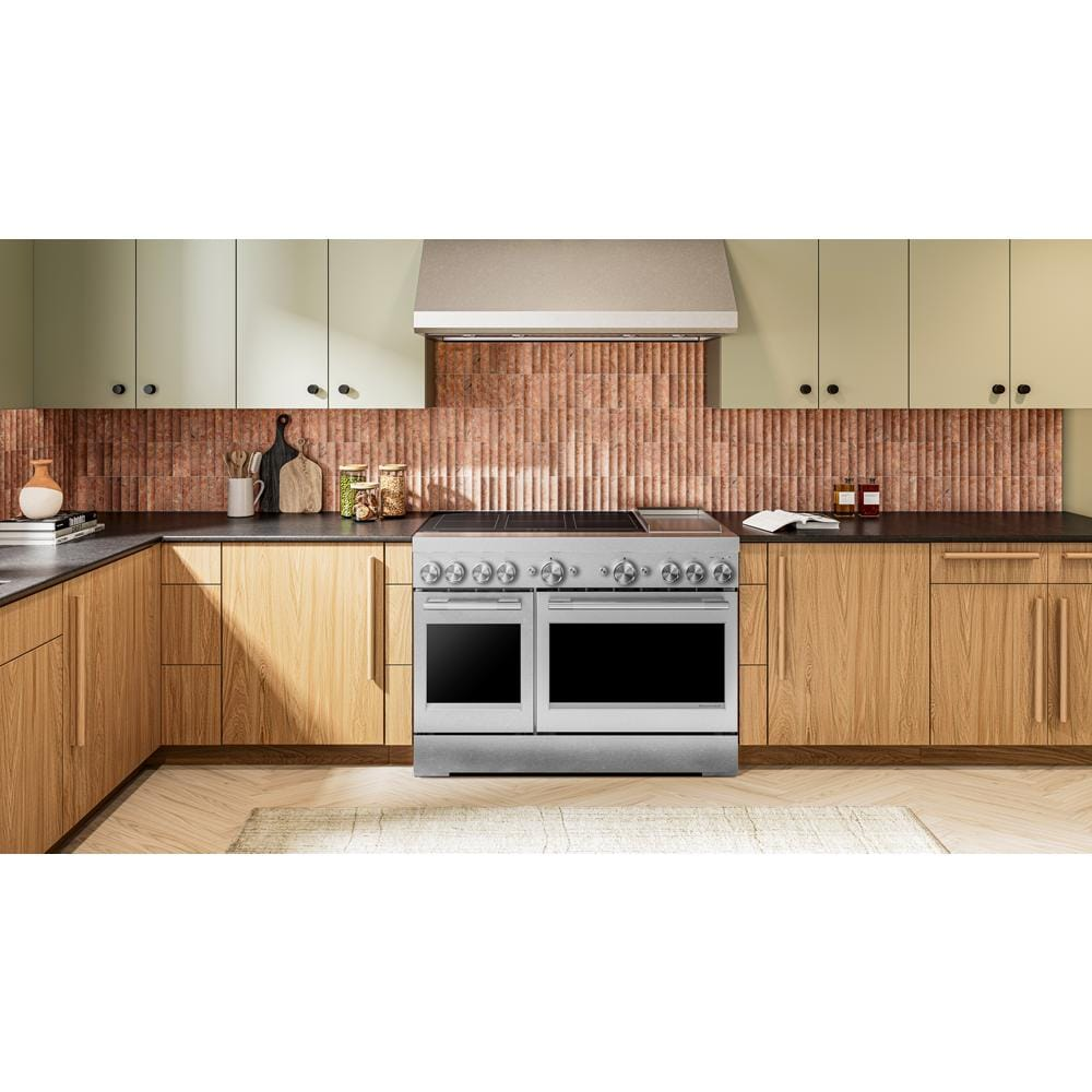 Commercial-style stainless steel 48-inch induction range with six elements, dual ovens, and integrated griddle in modern kitchen
