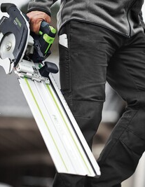Person holding a Festool cordless carpentry saw with guide rail, part of battery powered power tools collection