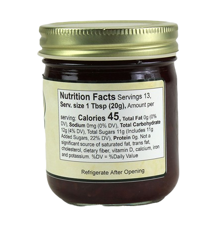 Jar of cherry jam showing nutrition facts label with calories, sugars, and other dietary information