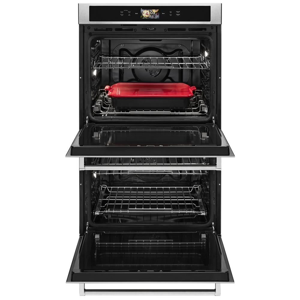 Open double wall oven with red ceramic dish on upper rack, stainless steel finish from KitchenAid appliances collection