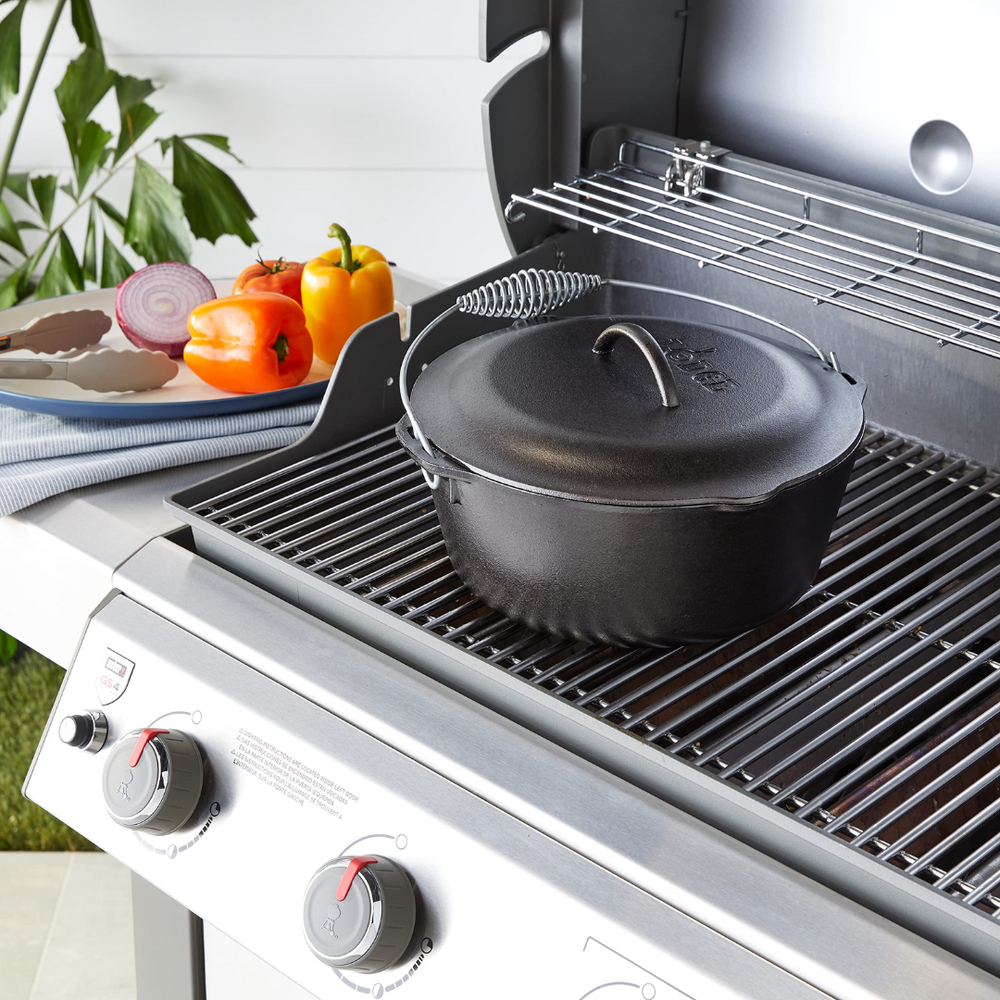 Black cast iron Lodge Logic Dutch oven with lid on outdoor gas grill in Kitchenware and Lodge Cast Iron collections under $100