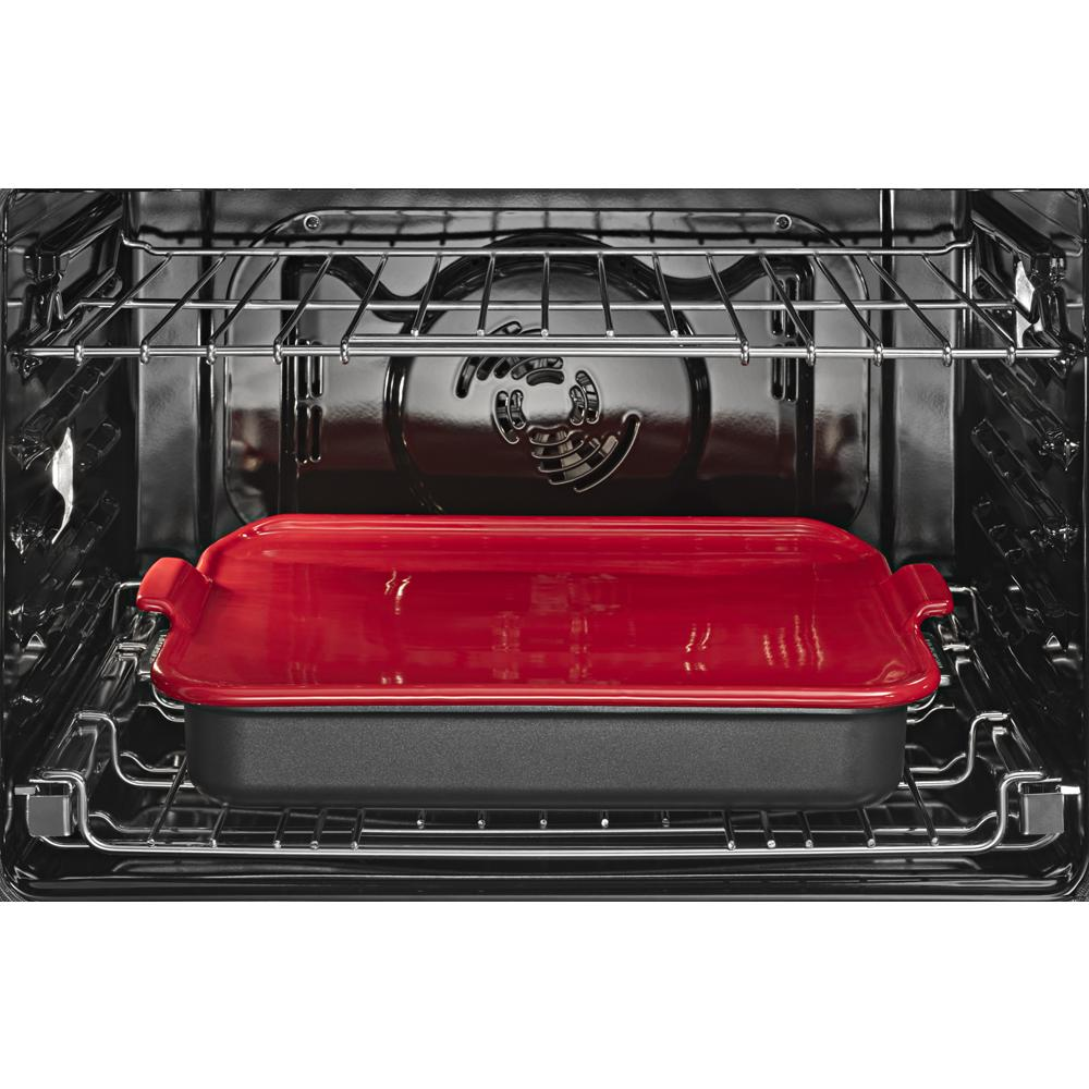 Inside view of oven with red ceramic casserole dish on middle rack in KitchenAid double wall oven collection