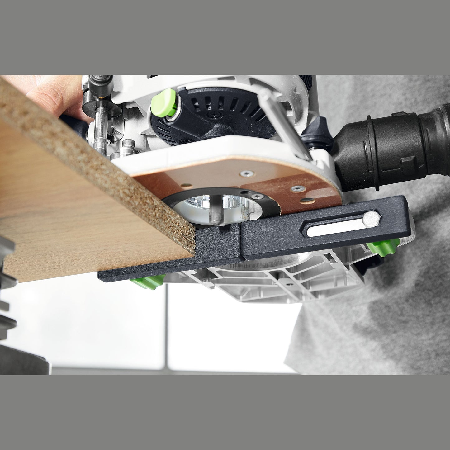 Close-up of a woodworking router using a parallel edge guide for precise cuts on wood in woodworking tool accessories collection