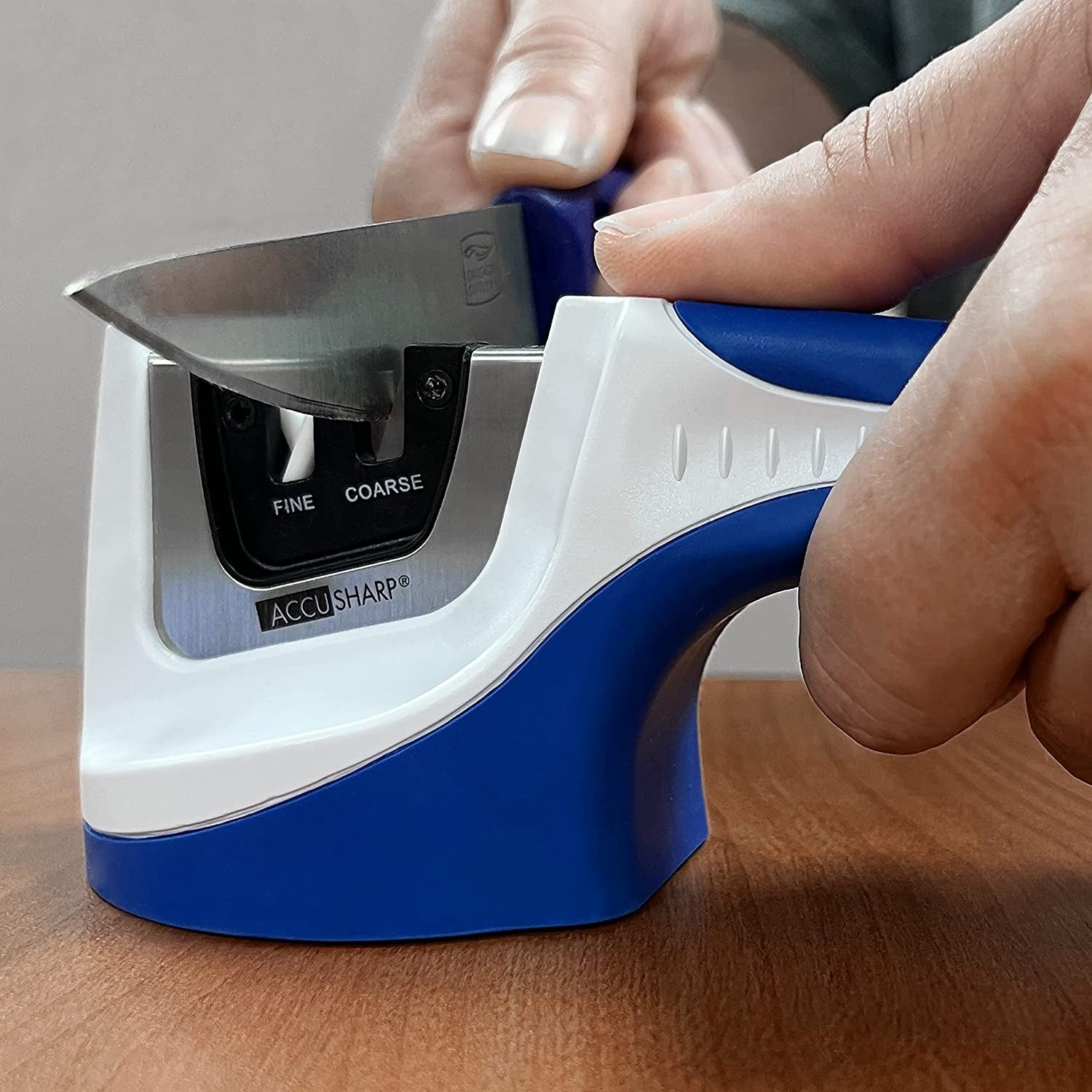 Blue and white handheld pull-through sharpener with tungsten carbide and ceramic rods used for home improvement and woodworking tools