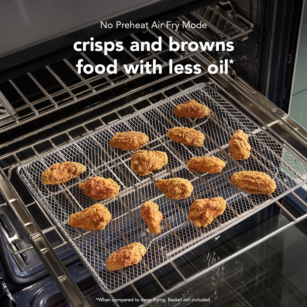 Fried chicken wings crisping on air fry rack inside electric double wall oven from KitchenAid Appliances.