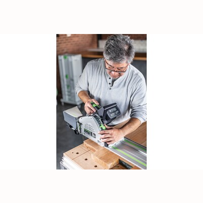 Man adjusting battery on Festool cordless track saw mounted on guide rail for power tools and home improvement