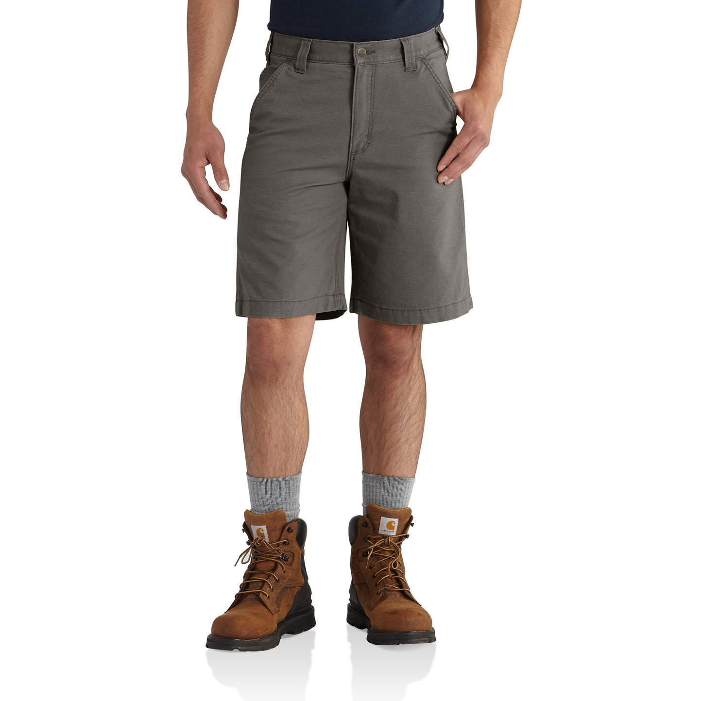 Men's rugged flex canvas work shorts in gravel color paired with brown work boots and gray socks