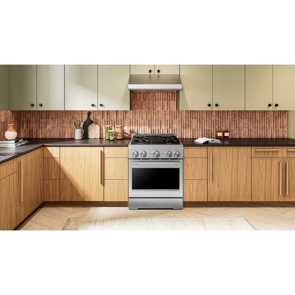 Stainless steel freestanding gas range with four burners in modern kitchen with wood cabinets and copper tile backsplash