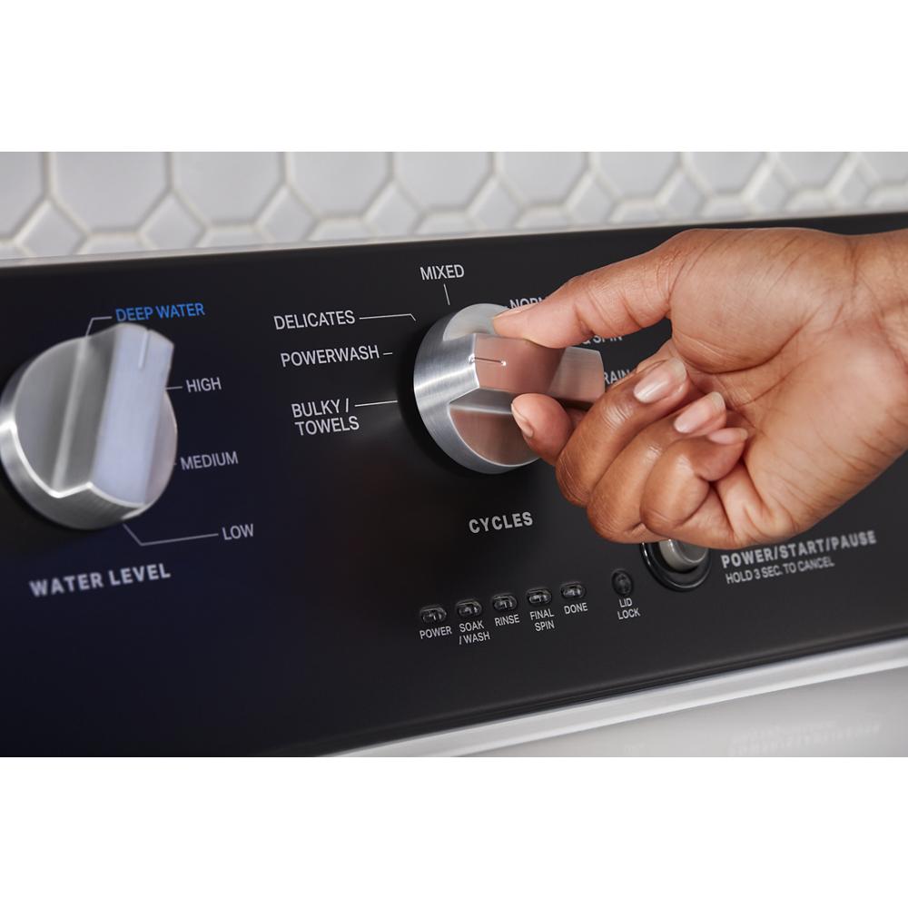 Hand turning cycle selector knob on a commercial-grade top load washer control panel from washers & appliances collection