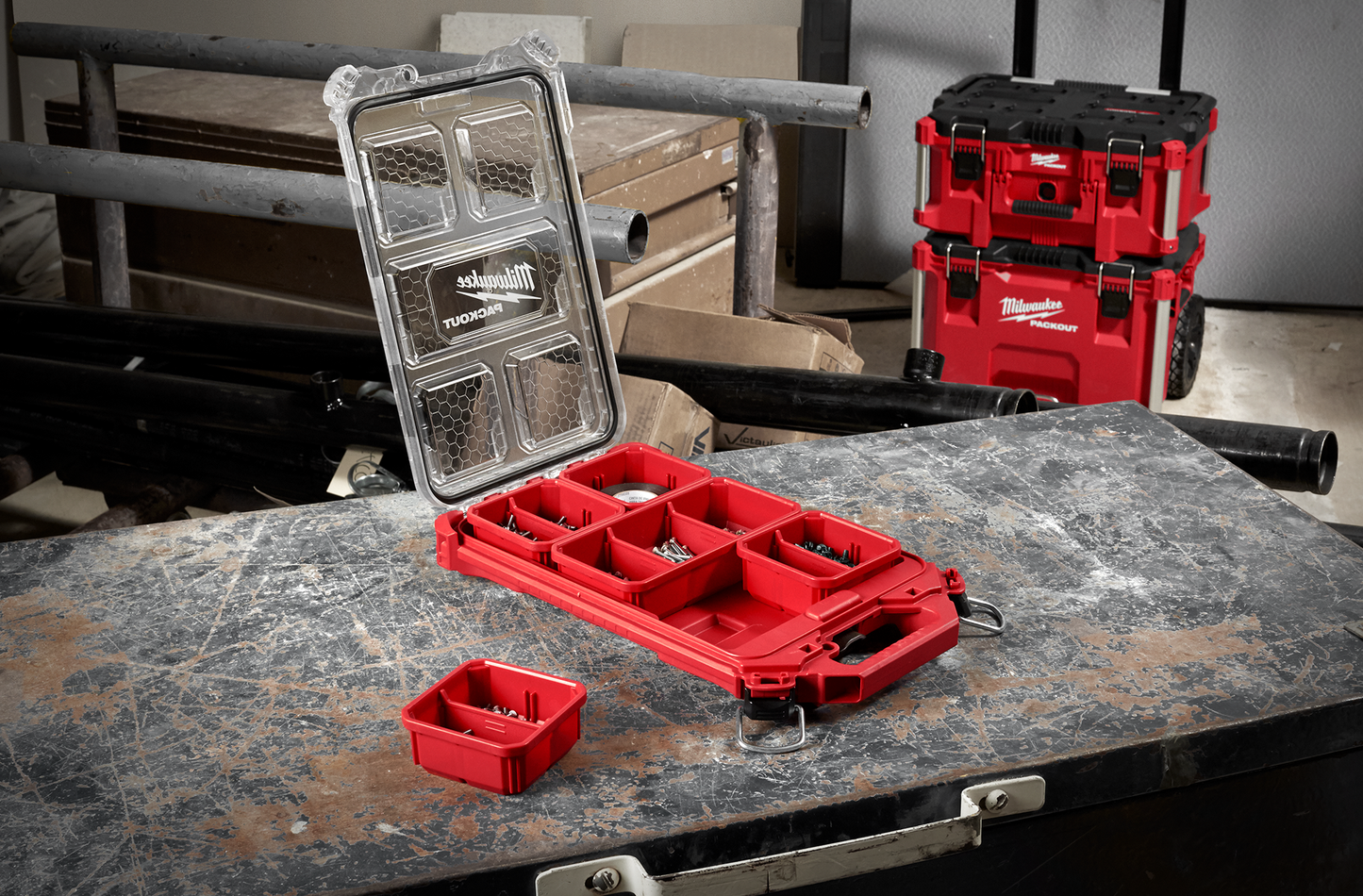 Red Milwaukee low-profile compact organizer with clear lid and removable bins for jobsite tool storage and workshop organization