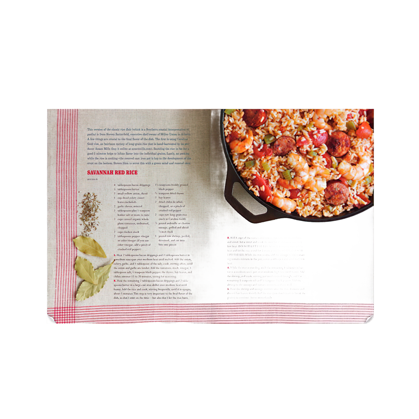 Open cookbook showing a Savannah Red Rice recipe alongside a cast iron skillet filled with cooked rice and sausage.