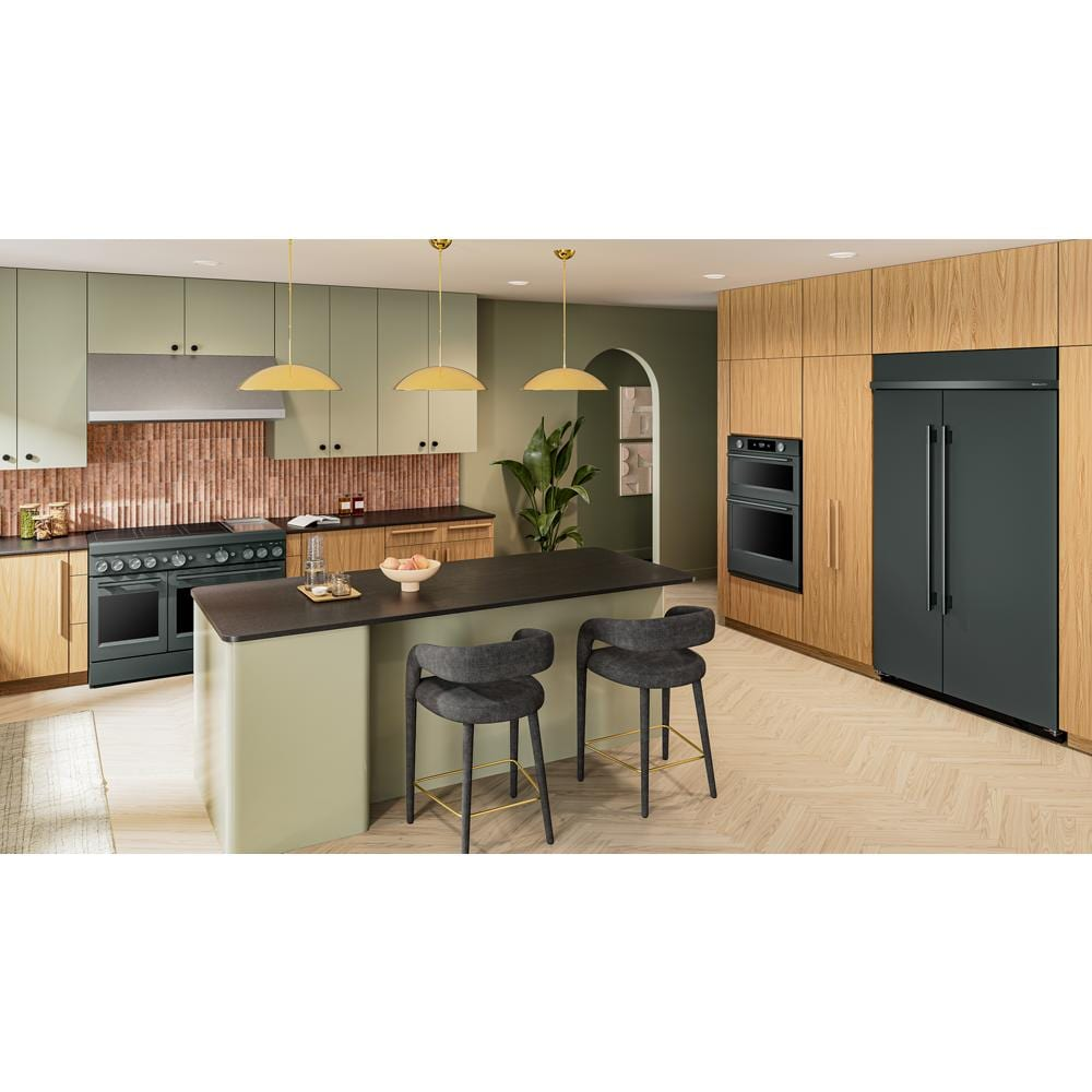Modern kitchen featuring a dark green induction range, built-in ovens, and matching refrigerator in wood-accented space