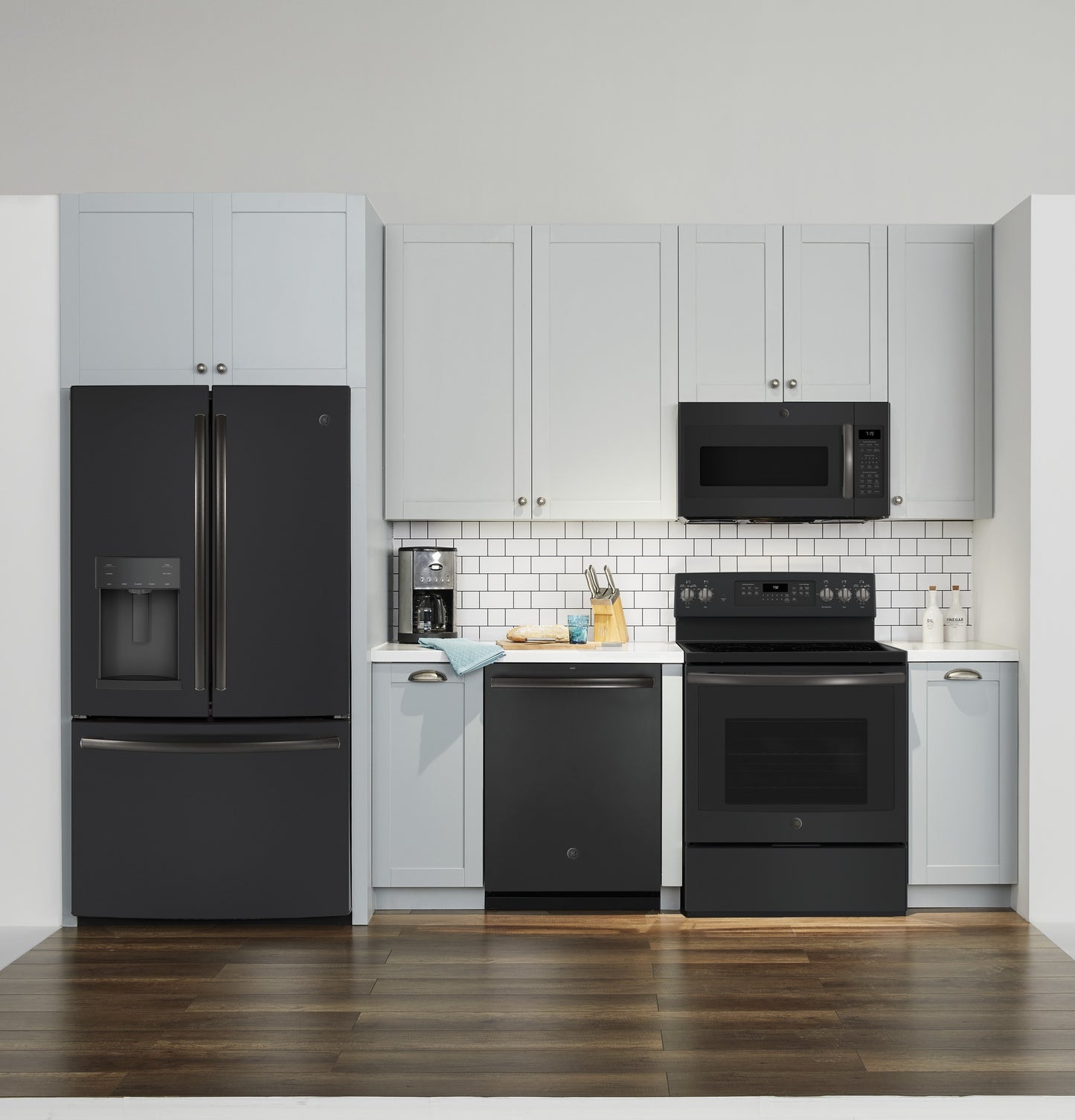 Modern kitchen setup with black appliances including refrigerator, dishwasher, stove, and over-the-range microwave in kitchenware collection