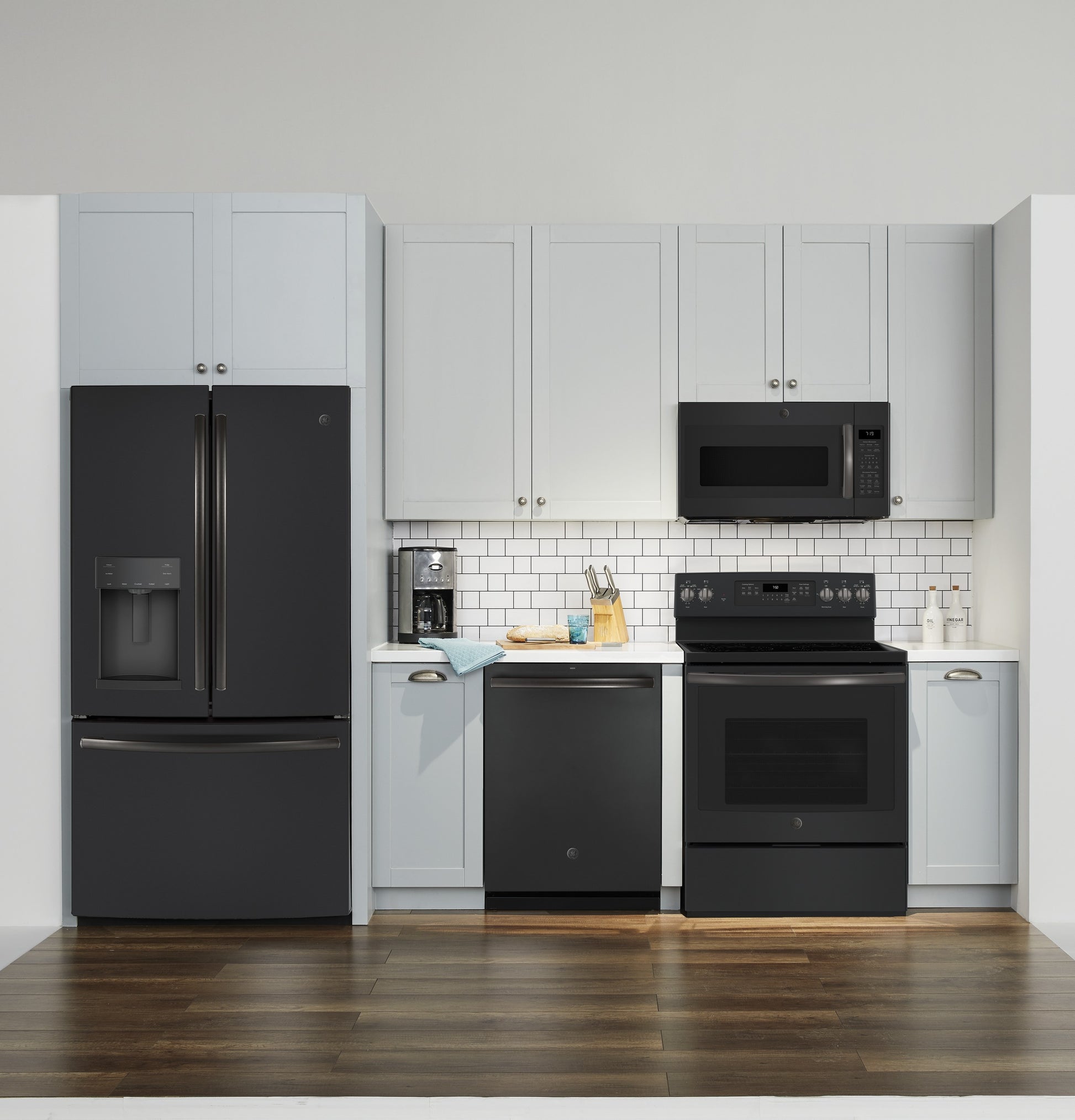 Modern kitchen setup with black appliances including refrigerator, dishwasher, stove, and over-the-range microwave in kitchenware collection