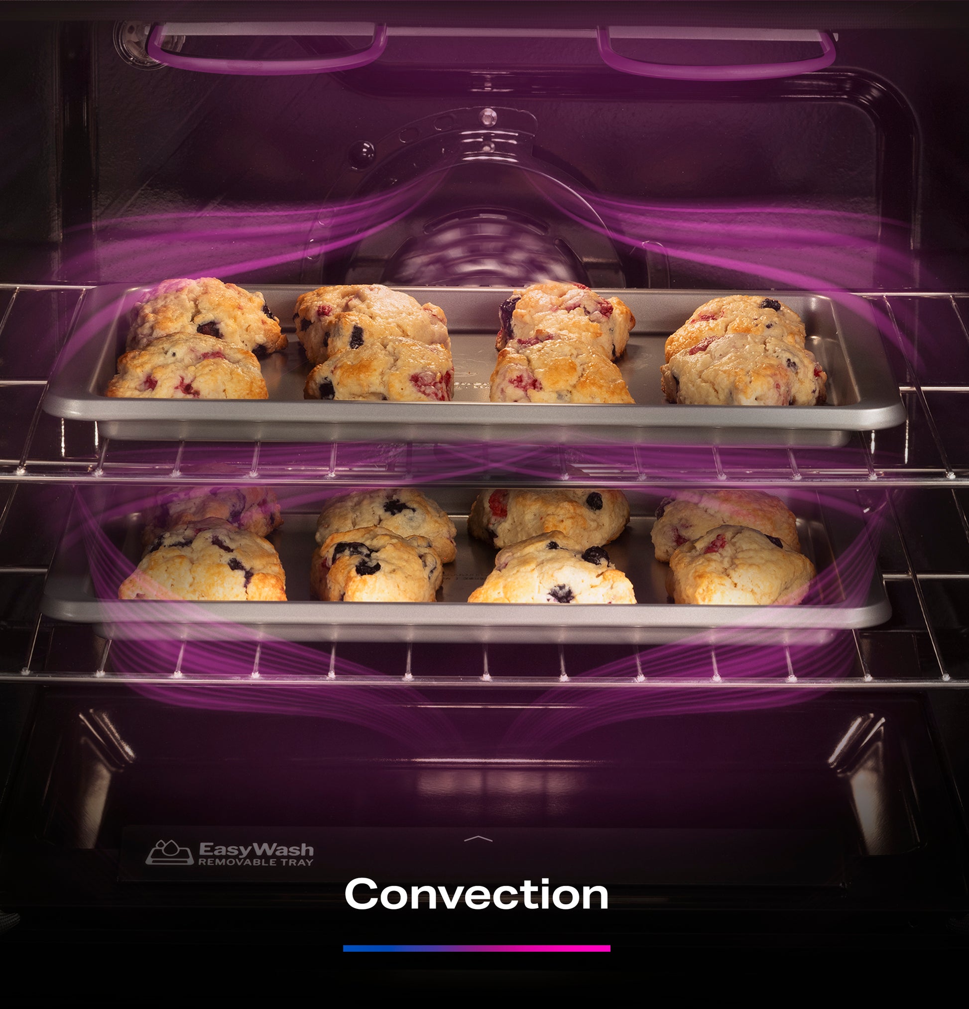 Two EasyWash™ removable trays with baked scones inside a convection oven with visible air circulation in a kitchen appliance.