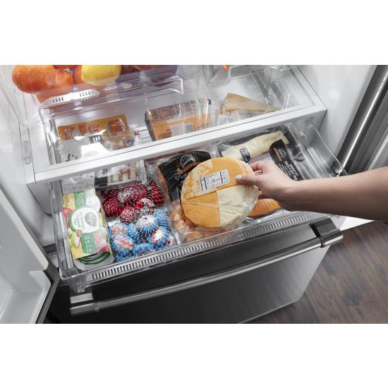 Person placing packaged cheese inside fingerprint resistant stainless steel French door refrigerator drawer from appliances collection