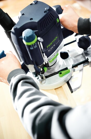 Person using Festool router with edge guide attachment for precise woodworking tool accessory in home improvement collection
