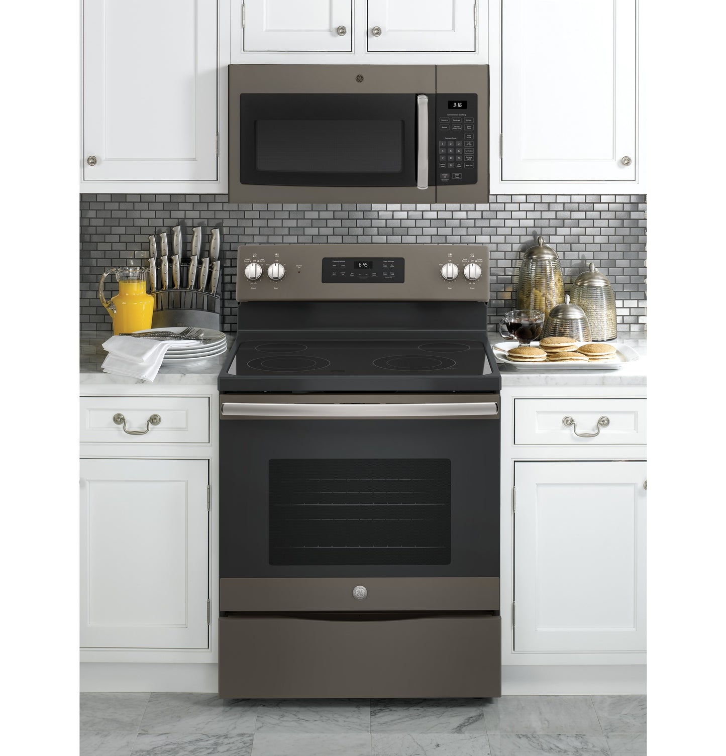 GE® 1.6 Cu. Ft. over-the-range microwave in stainless steel installed above matching electric range in modern kitchen setting