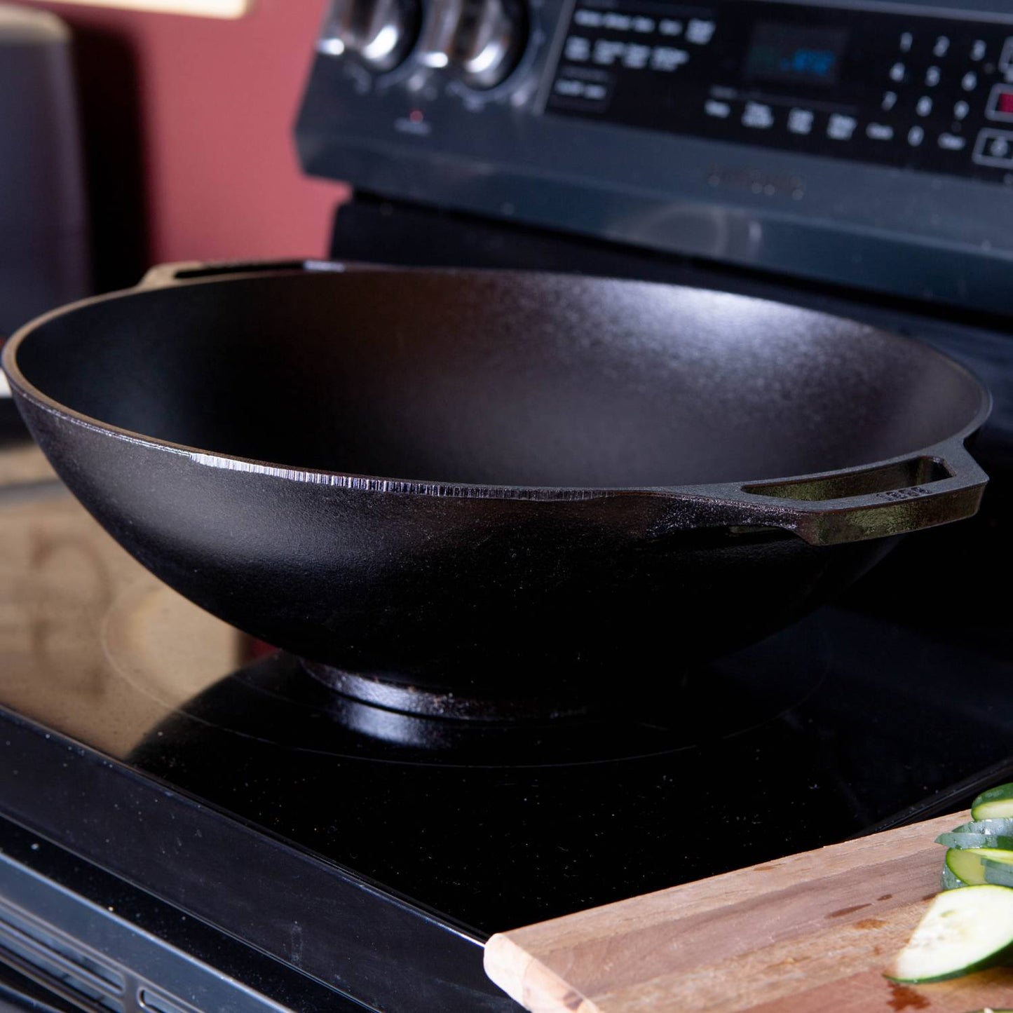 Wide-base cast iron wok with handle on stovetop, part of Kitchenware and Lodge Cast Iron collections under $100