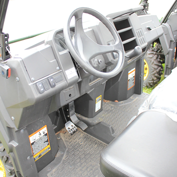 Interior view of a full-size utility vehicle with steering wheel, pedals, and durable flooring for home improvement use