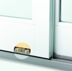Close-up of a dual ball-bearing roller assembly installed on a sliding patio door track for smooth operation.