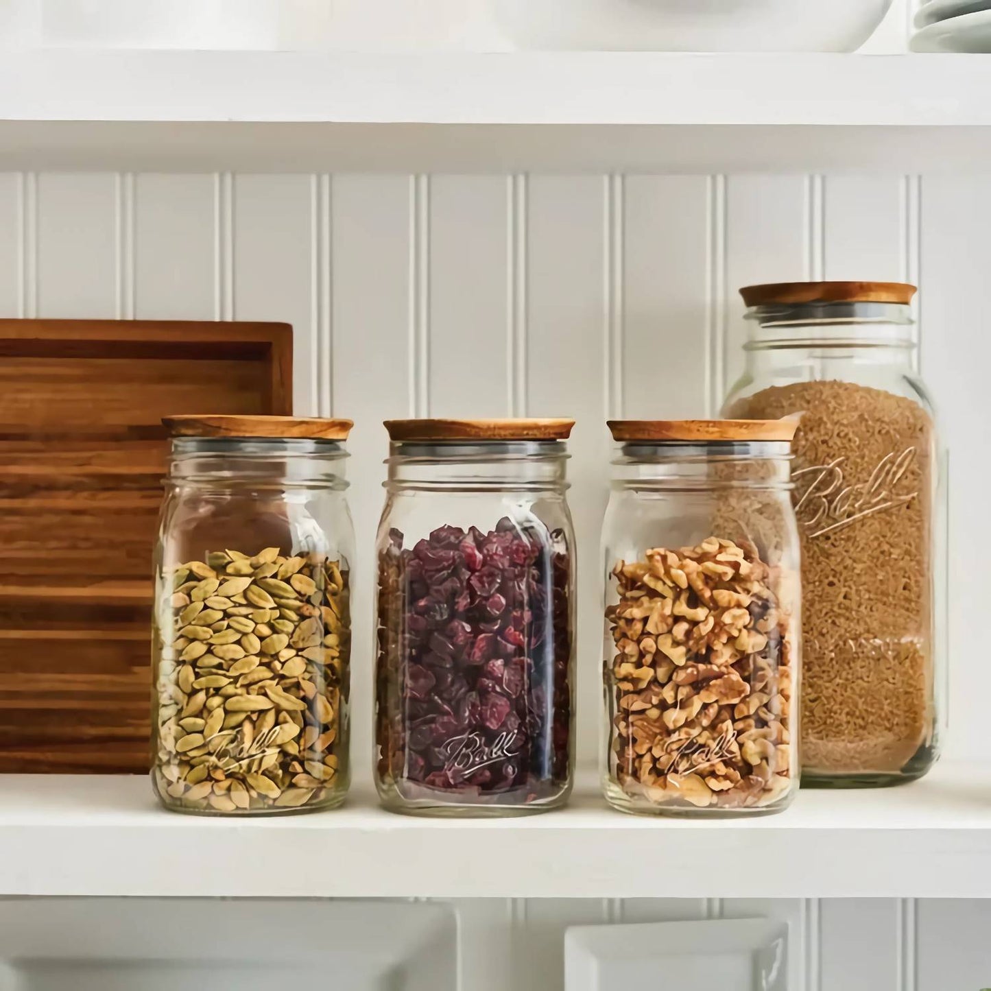 Three glass jars with wooden lids filled with seeds, dried fruit, and nuts in Kitchen Gadgets and Kitchenware collections