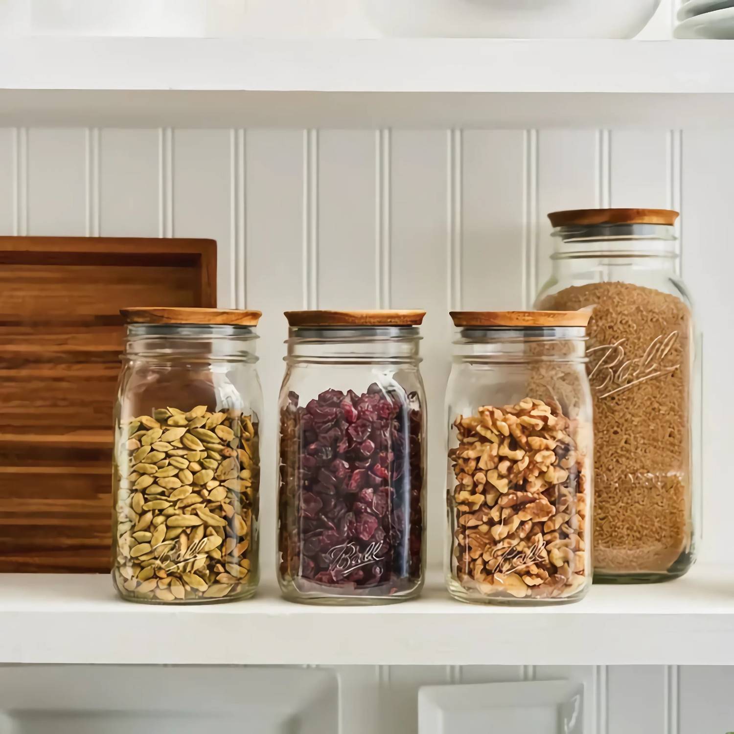 Three glass jars with wooden lids filled with seeds, dried fruit, and nuts in Kitchen Gadgets and Kitchenware collections