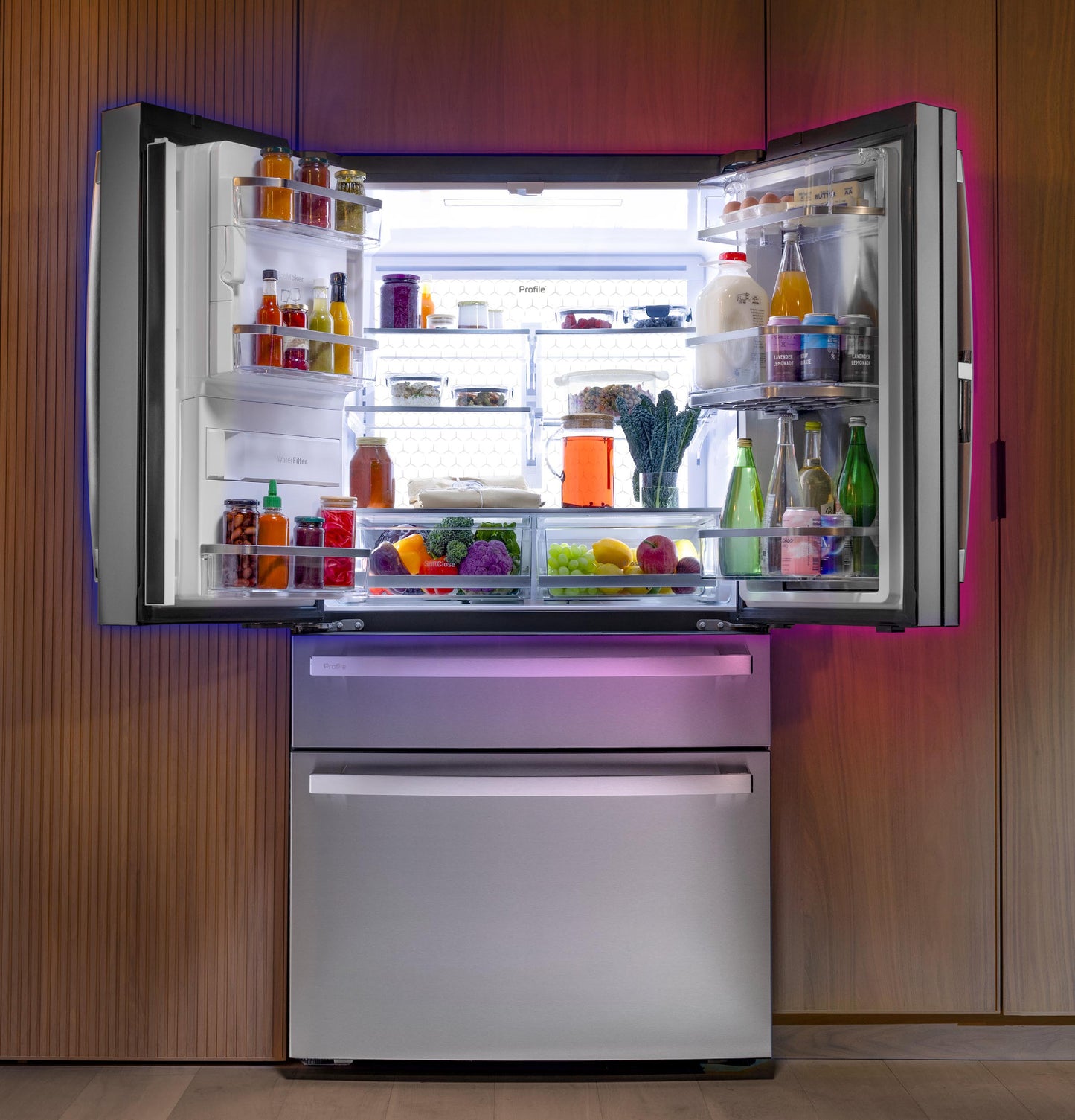 Modern stainless steel French-door refrigerator with bright interior light and organized shelves in kitchen setting