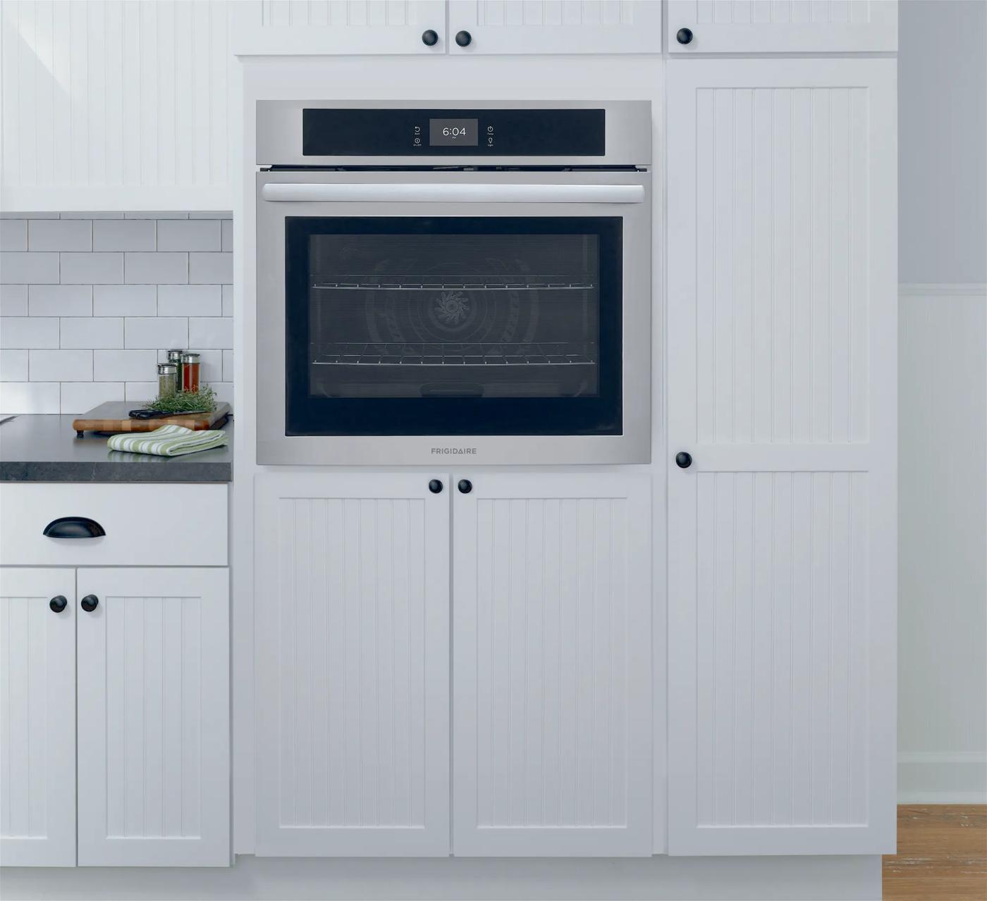 Built-in stainless steel electric wall oven with digital display integrated into white kitchen cabinetry from wall ovens collection