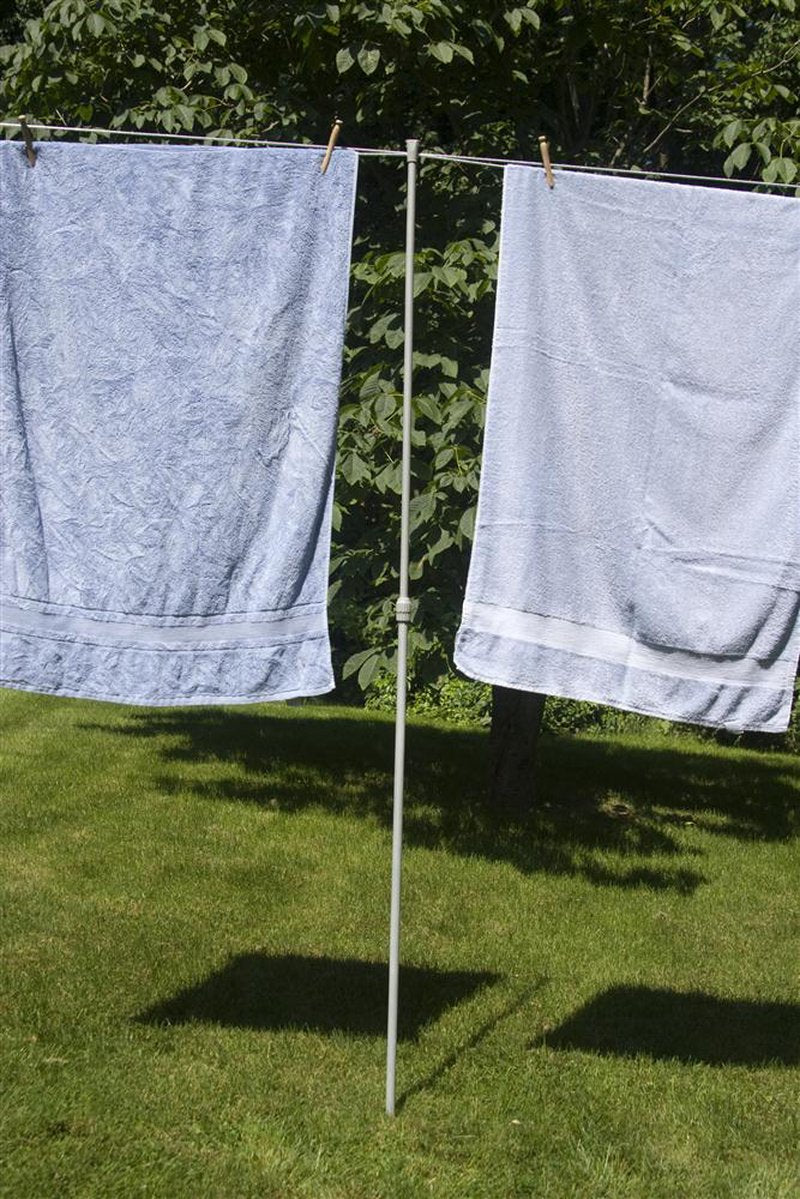 Metal telescoping clothesline prop supporting line with towels in outdoor storage and organization setup under $50 collections