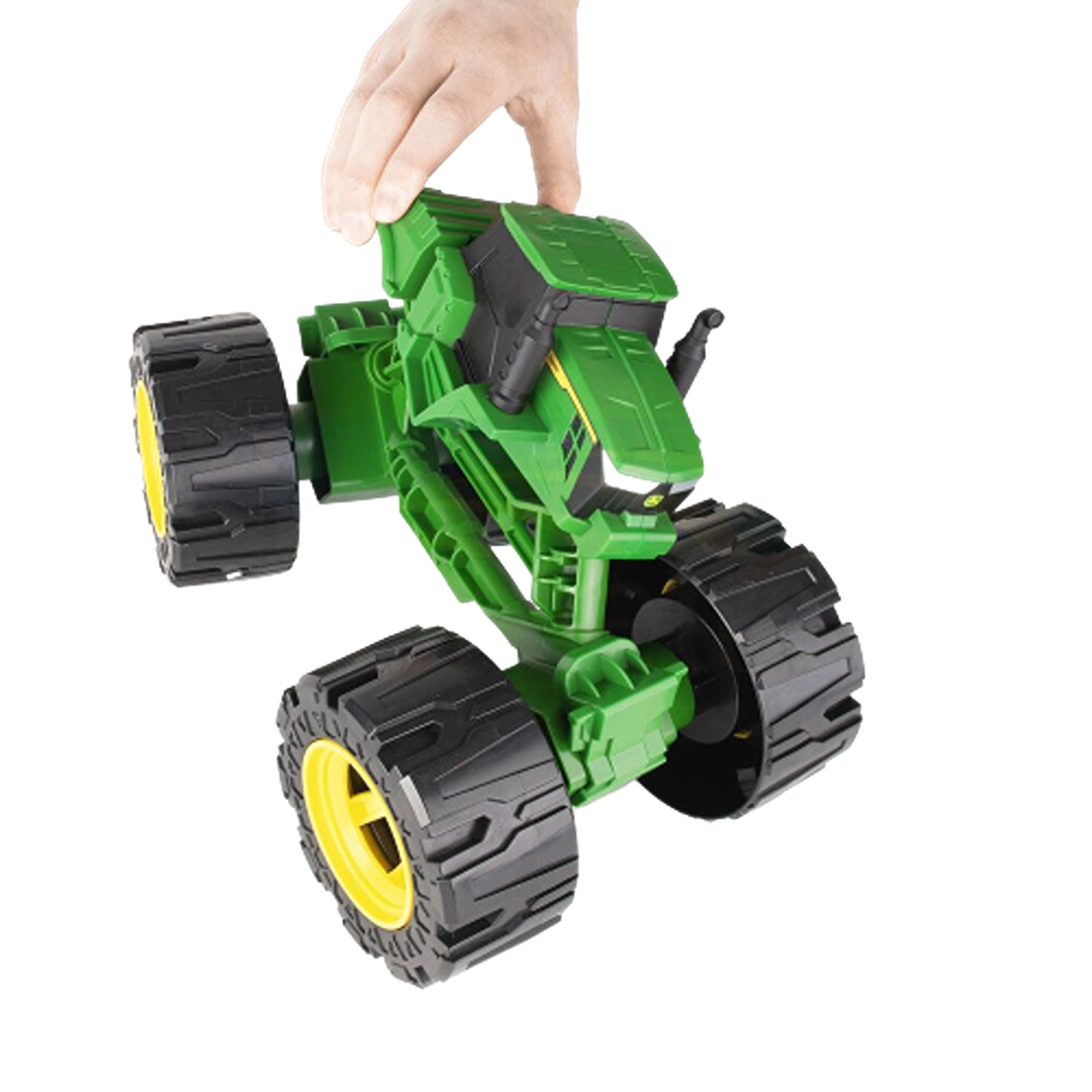 Green all-terrain toy tractor with oversized yellow-rimmed tires held by a hand for outdoor play and fun