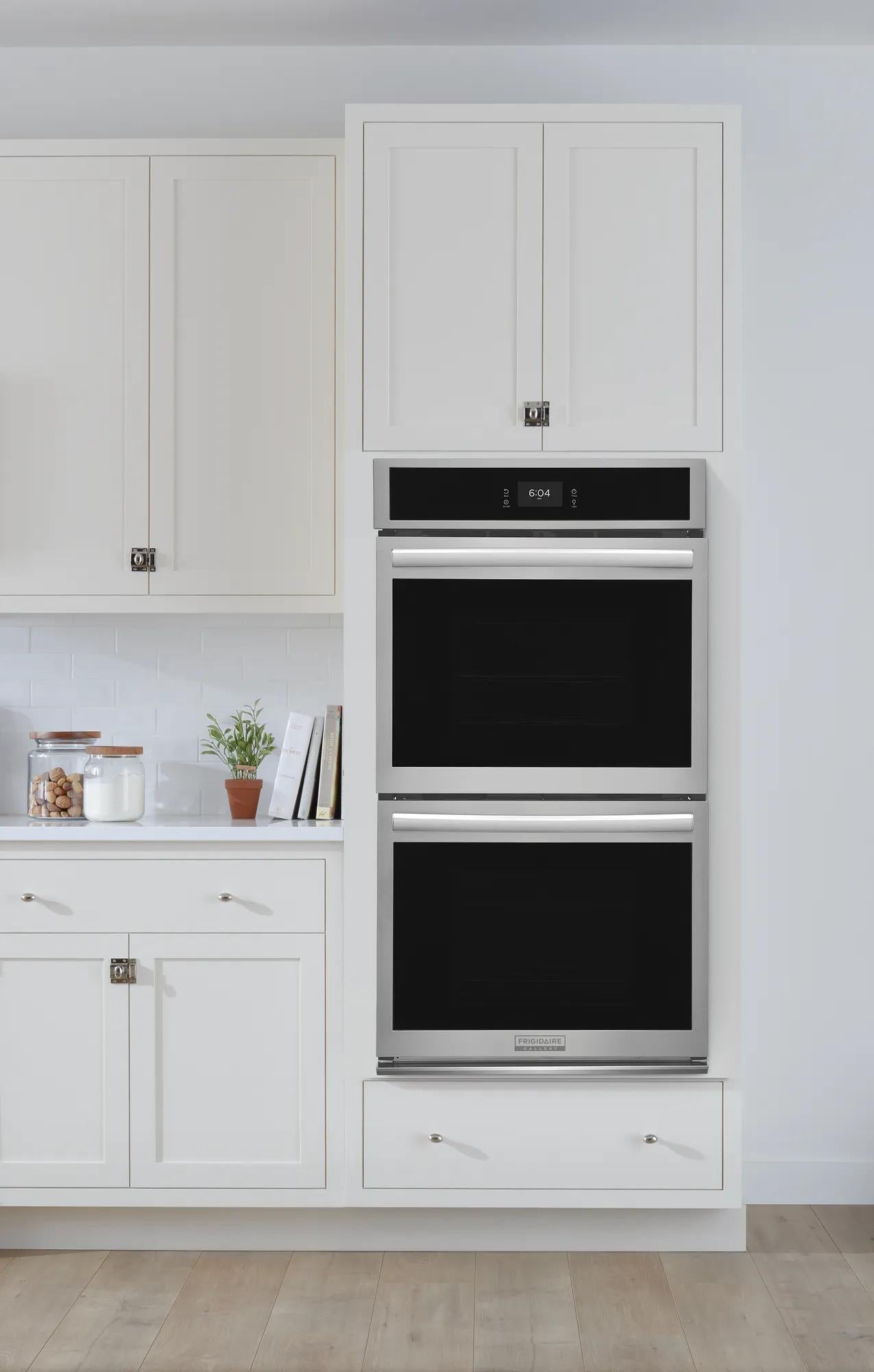 Built-in stainless steel double wall oven with convection feature integrated into white kitchen cabinetry