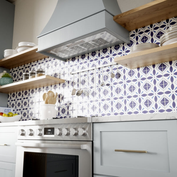Kitchen with gray range hood, patterned tile backsplash, wooden open shelves, and stainless steel oven appliances