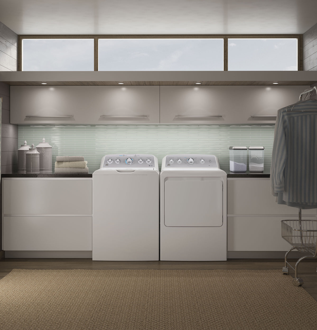 Laundry room with white top-load washer and matching electric dryer, modern cabinets, and soft natural lighting from clerestory windows