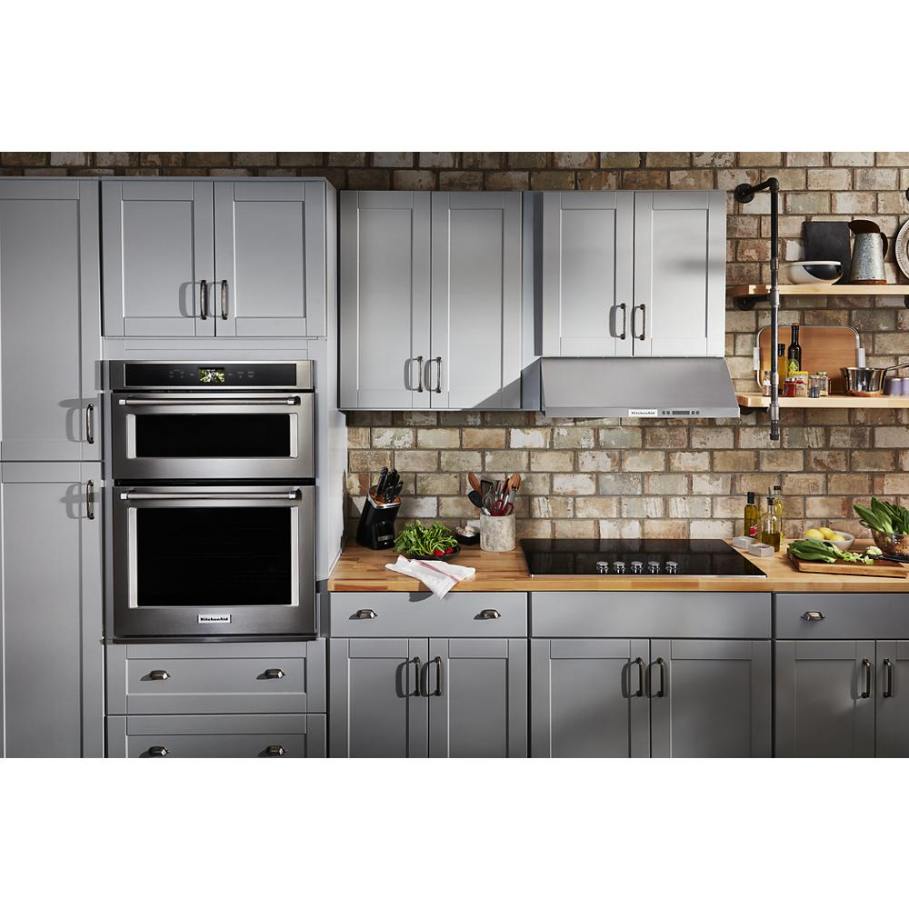 Modern kitchen featuring gray cabinetry, built-in stainless steel double oven, and electric cooktop with hood vent