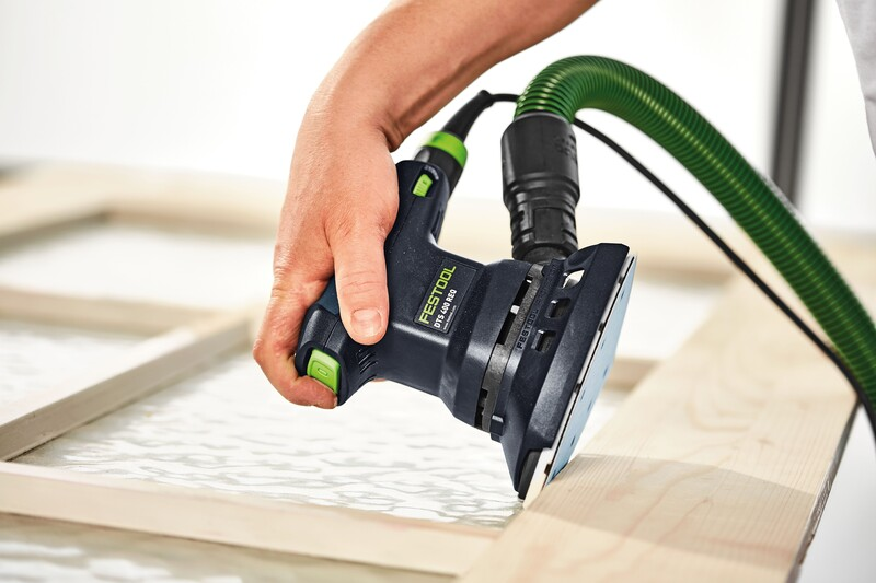 Handheld Festool sander with green dust extraction hose used in woodworking tool accessories for precise surface finishing
