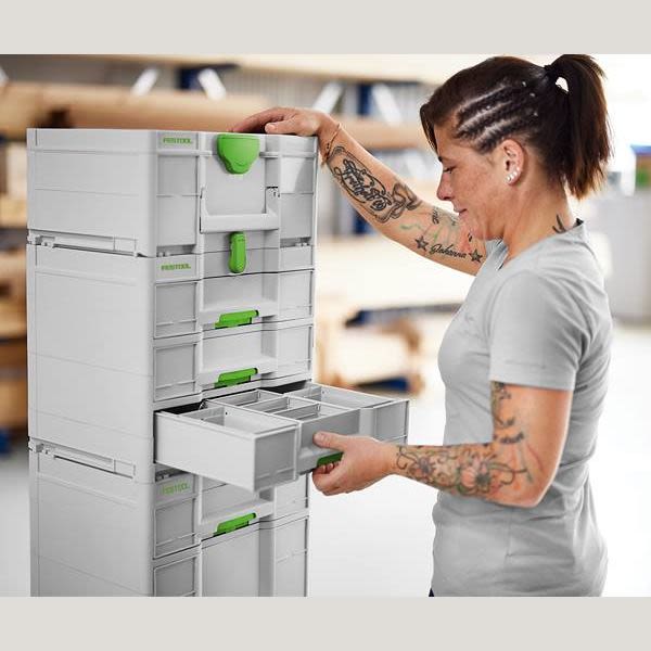 Person opening drawer of white and green Festool storage system for workshop organization and tool storage accessories
